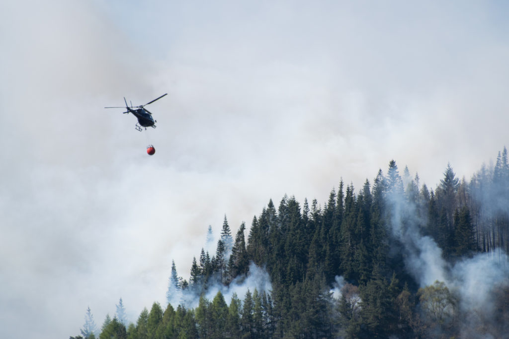 Helicopter dropping water to extinguish wildfire