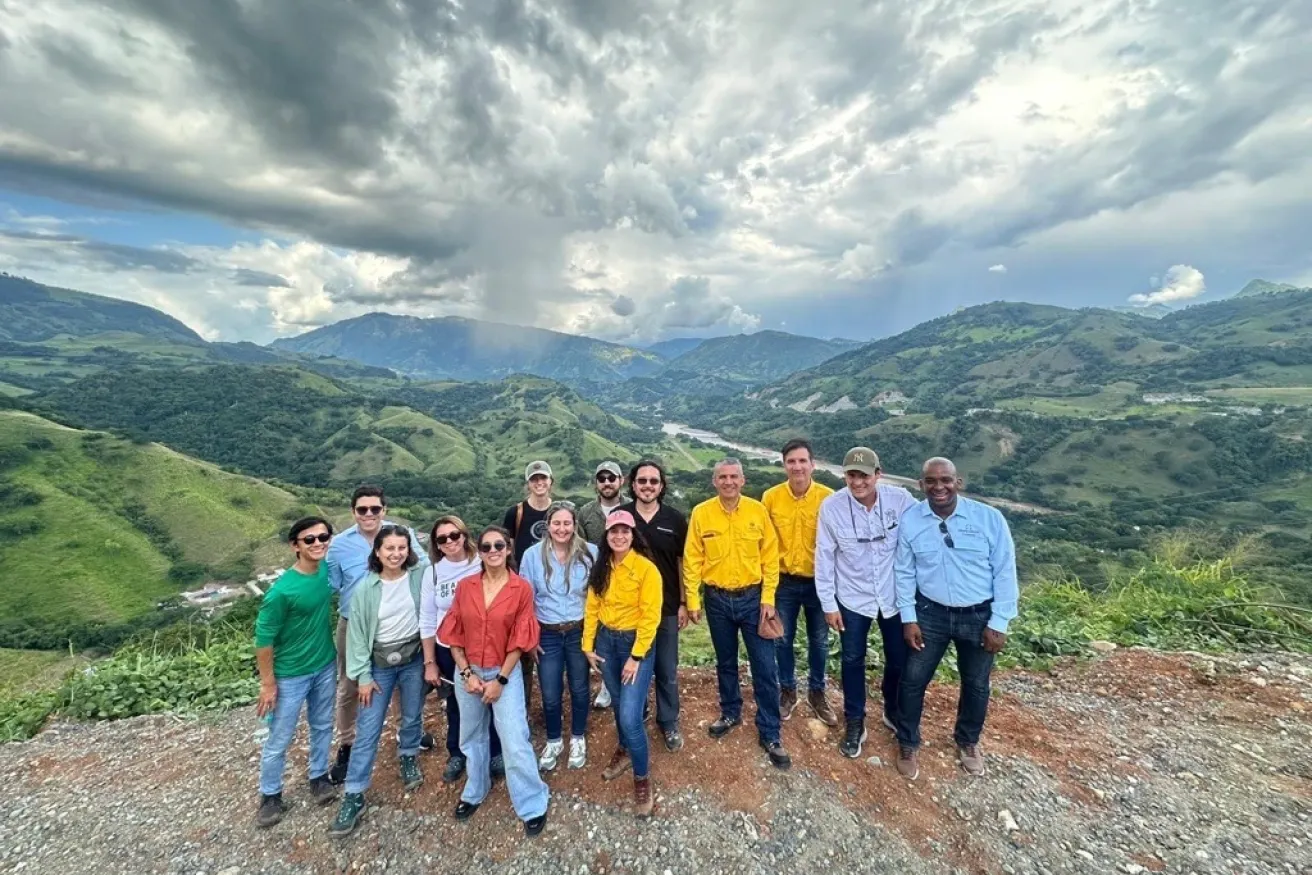 A diverse group of individuals standing on a mountain peak.