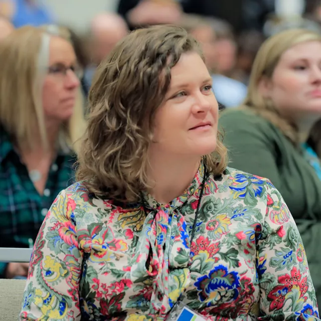 Woman listening to speaker at a conferece