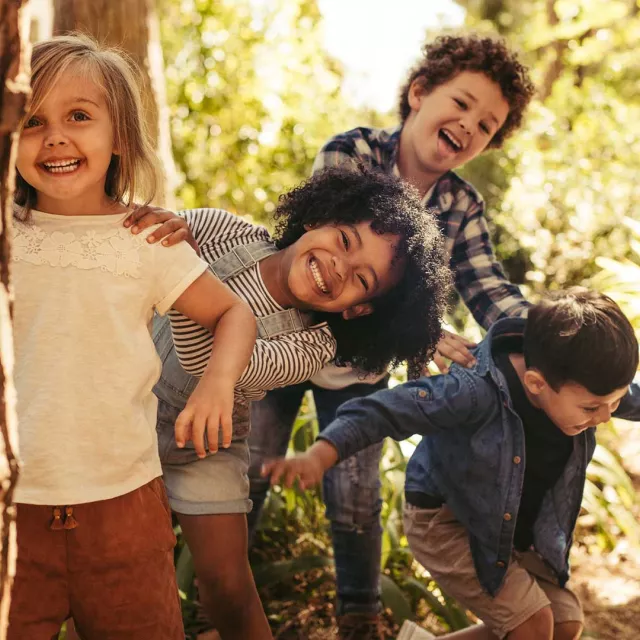 Children playing next to a tree