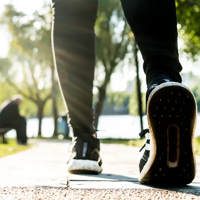 close-up of feet walking on park path.