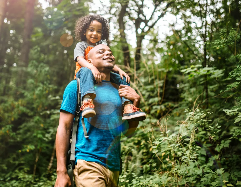 man with young boy in forest