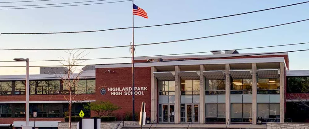 Highland Park High School building's front view with a flag waving.