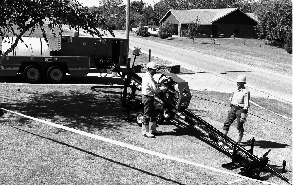 construction workers doing underground work near trees