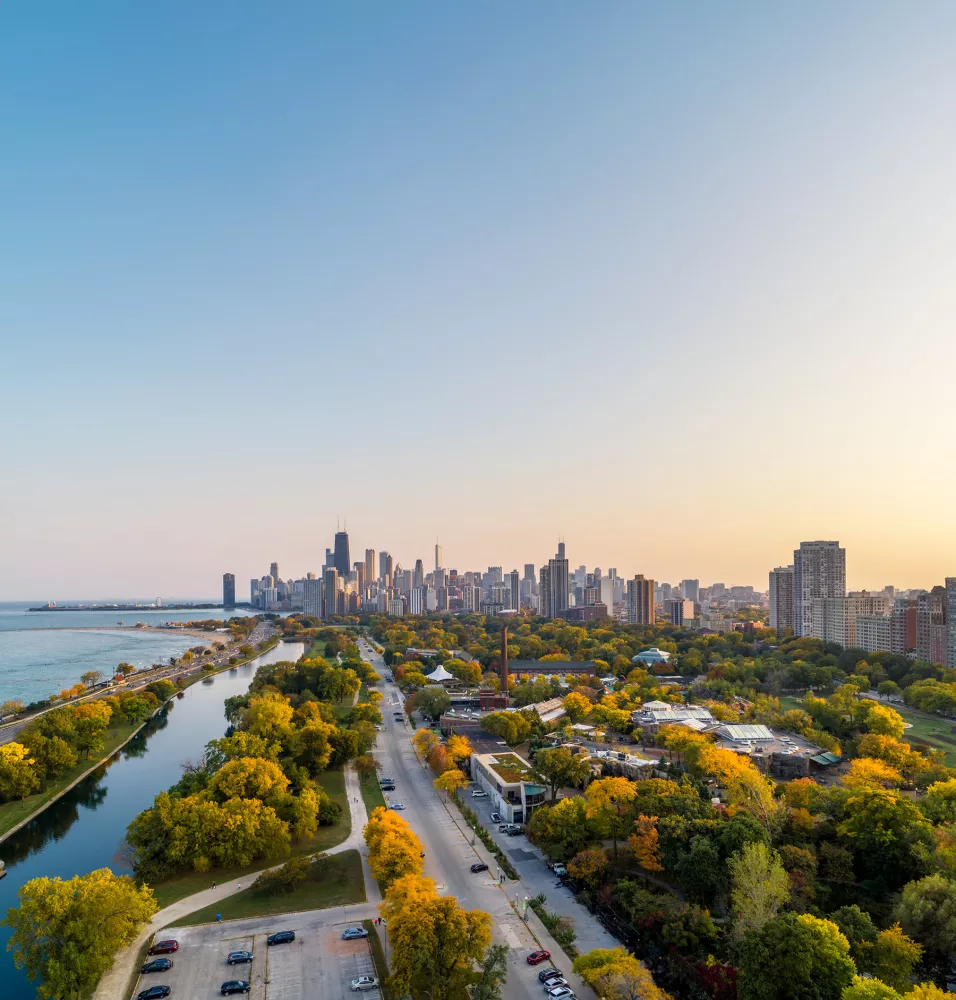 Aerial view of Chicago's skyline with vibrant autumn colors and Lake Michigan shimmering below.