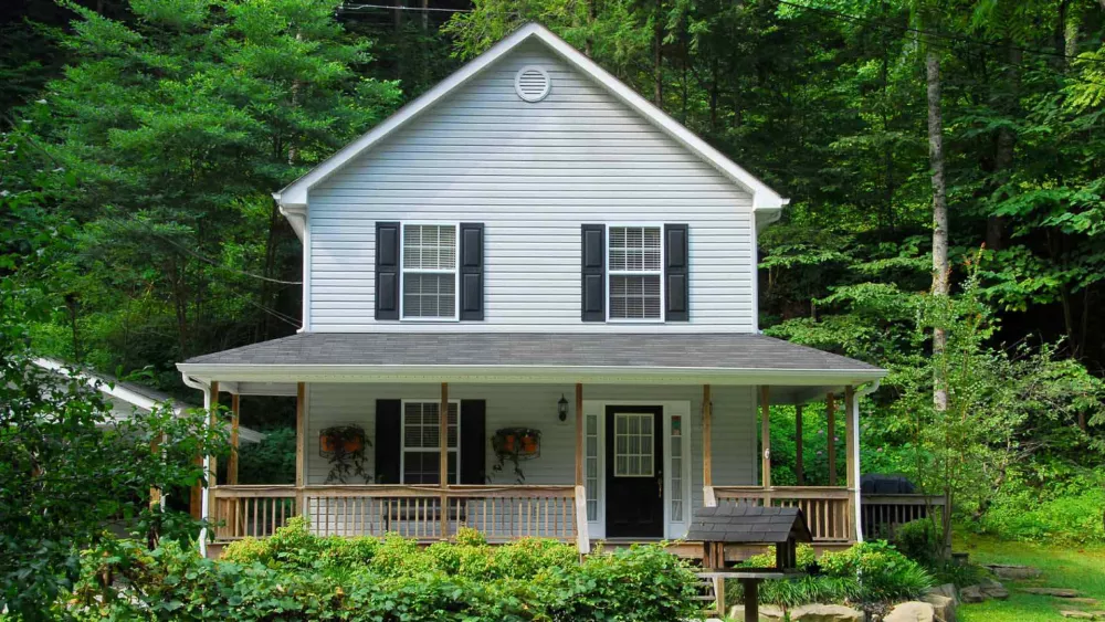 Image of a white house with wooded backyard