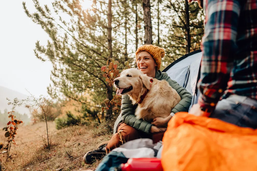 person with a dog outside enjoying nature and trees