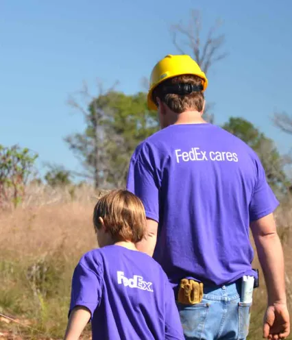 Photo of adult with hard hat and child in field