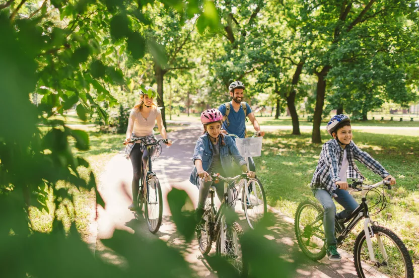 family riding bikes around trees