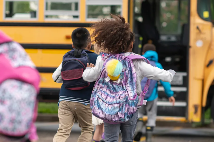 elementary school students running to the bus.