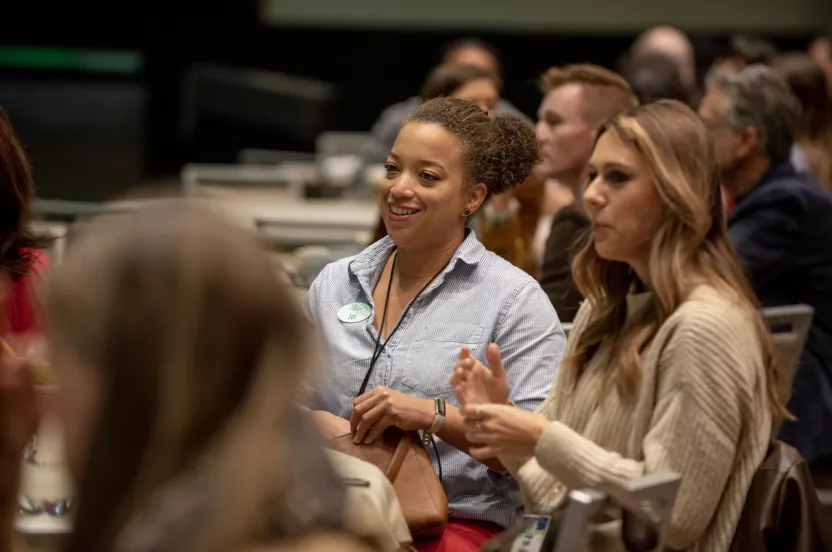 Two women sitting around a table at a conference.