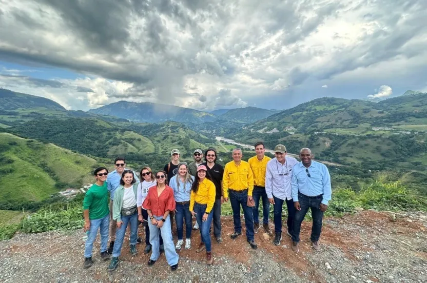 A diverse group of individuals standing on a mountain peak.