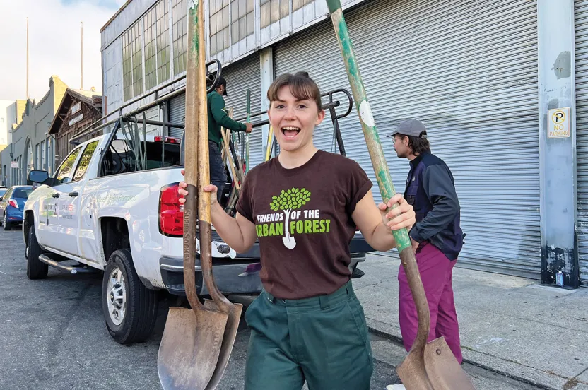 Girl holding shovels smiling