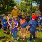 Group of children watching how to plant a tree.