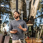 Man talking to table of people outside